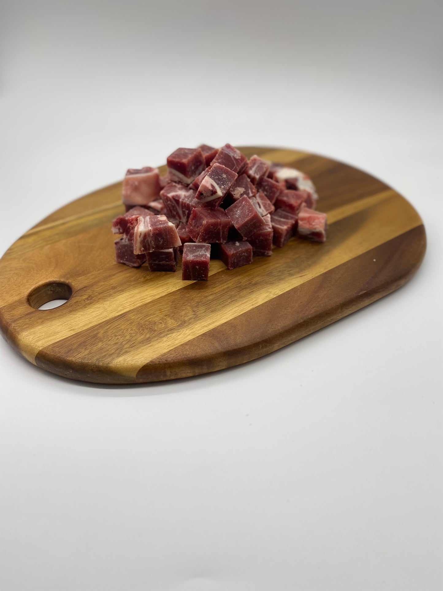 Picture of diced goat with bone in n a wooden board