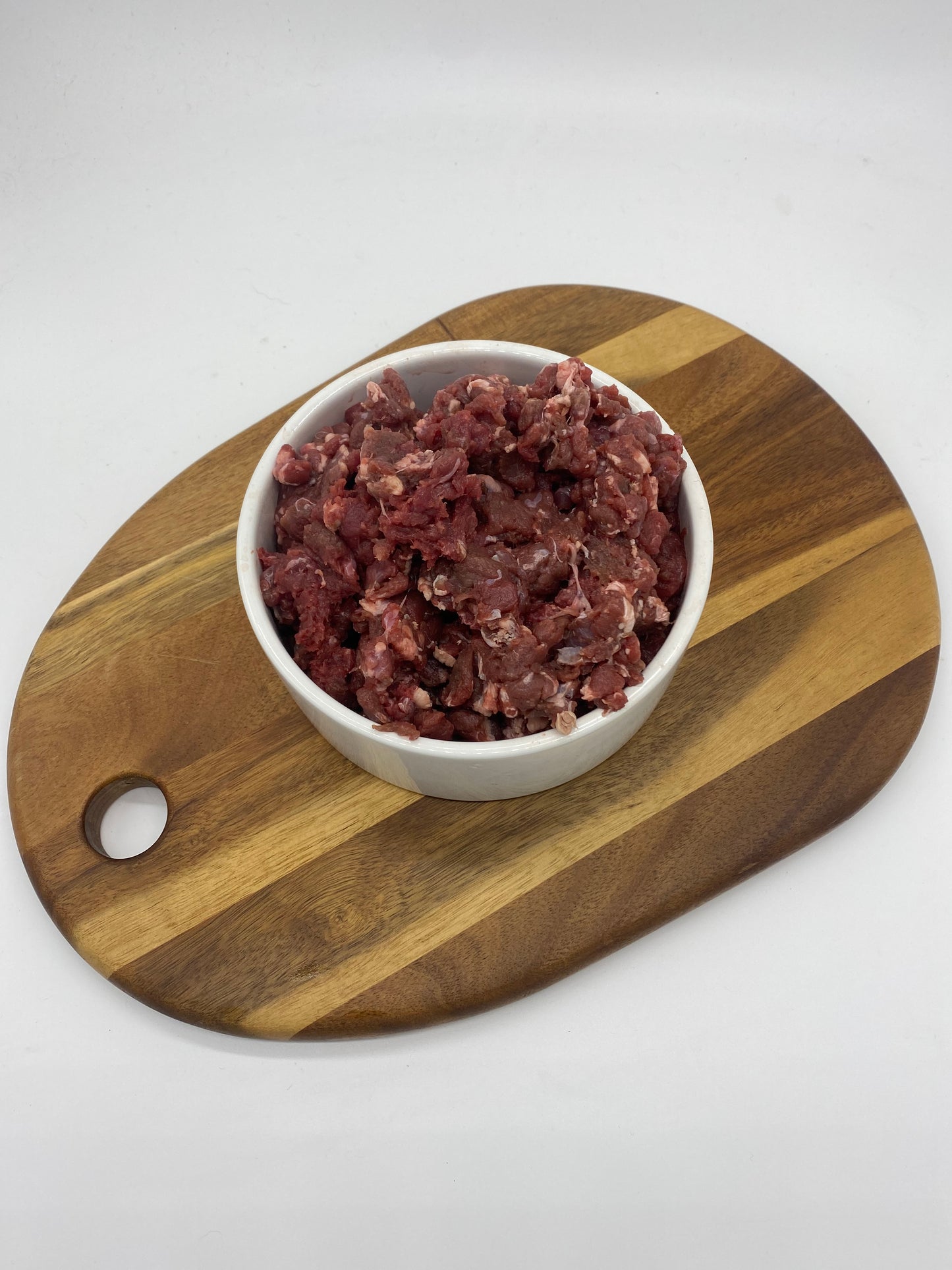 Minced venison in a white bowl top view