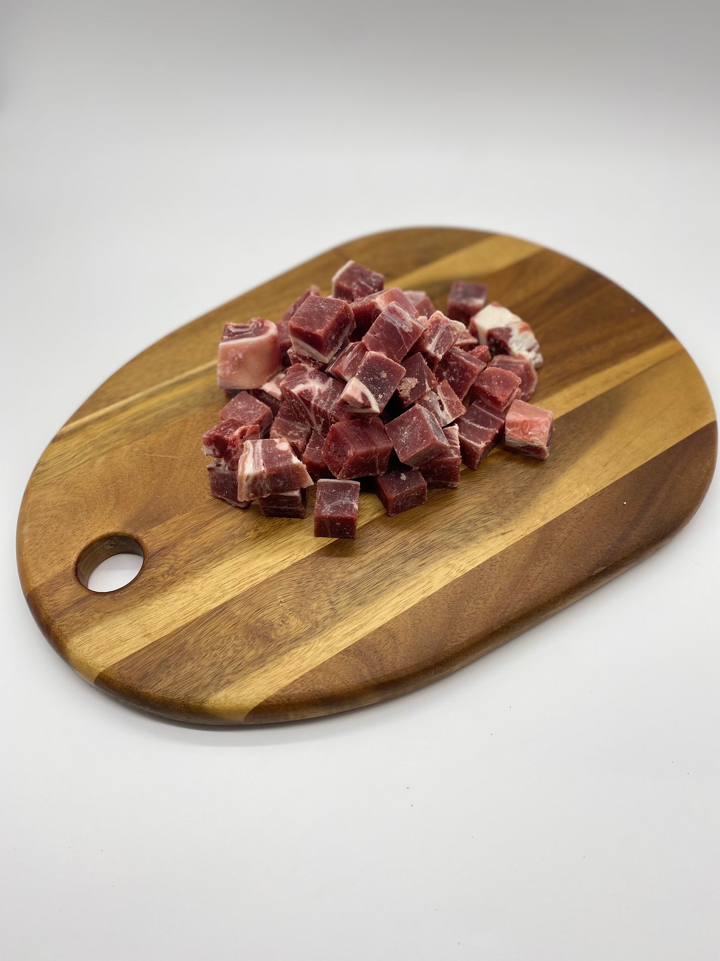 Diced goat with bone in on a wooden board