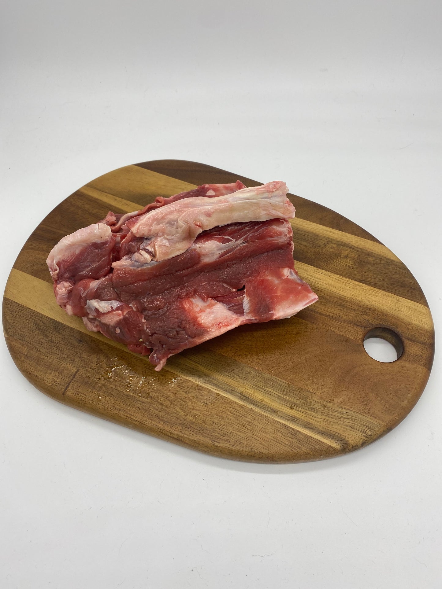 Photo - raw goat spine section on a wooden board