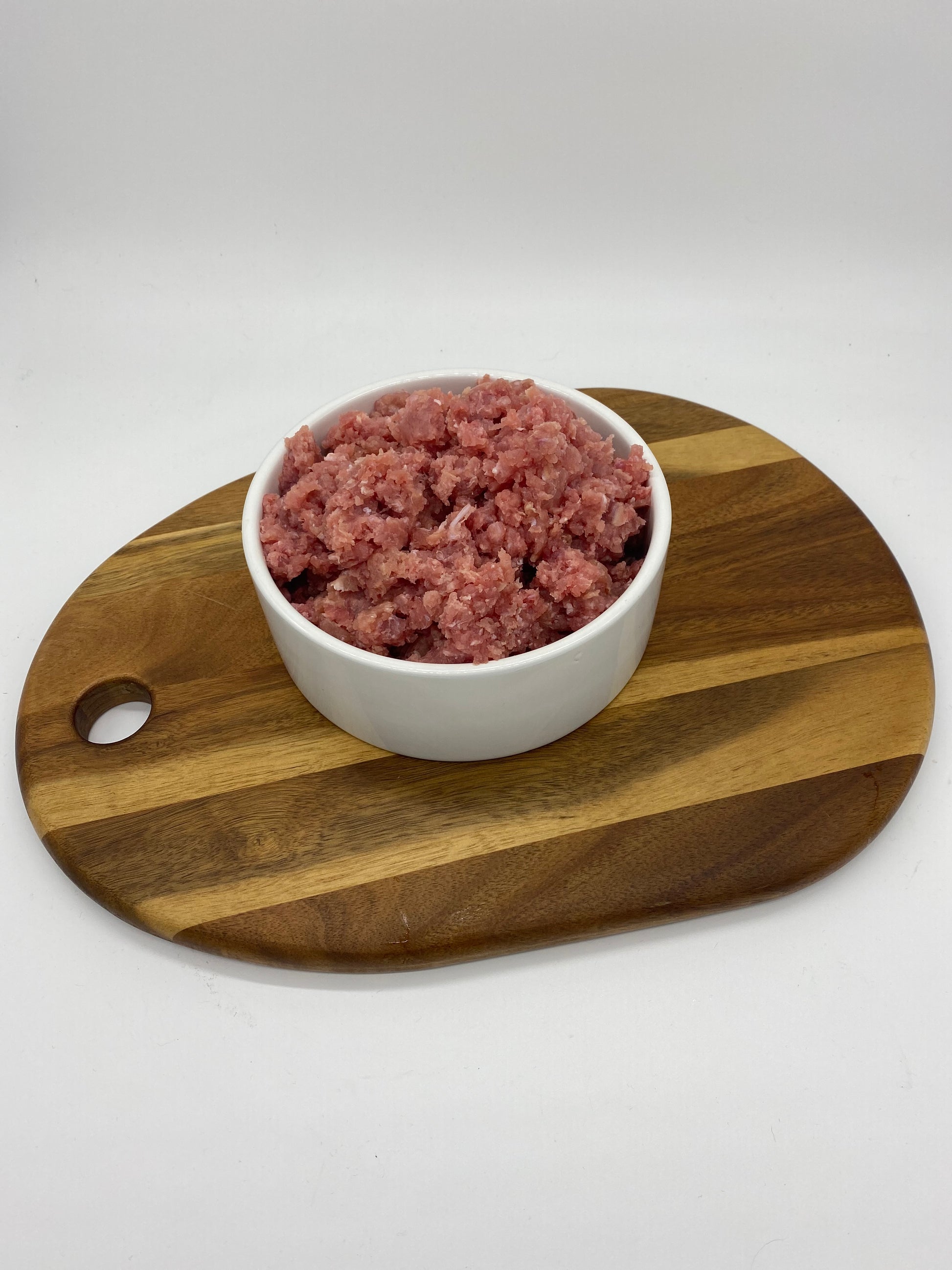 Photo - Rabbit Mince in a dog bowl on a wooden board