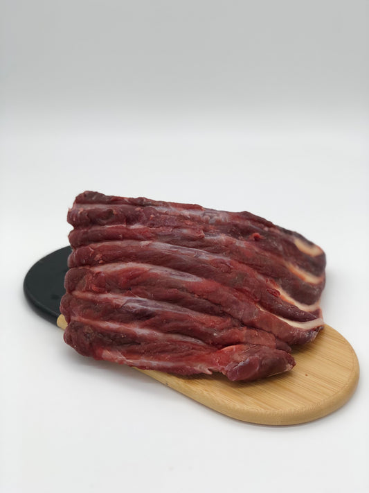 Photo - Raw kangaroo ribs on a wooden board